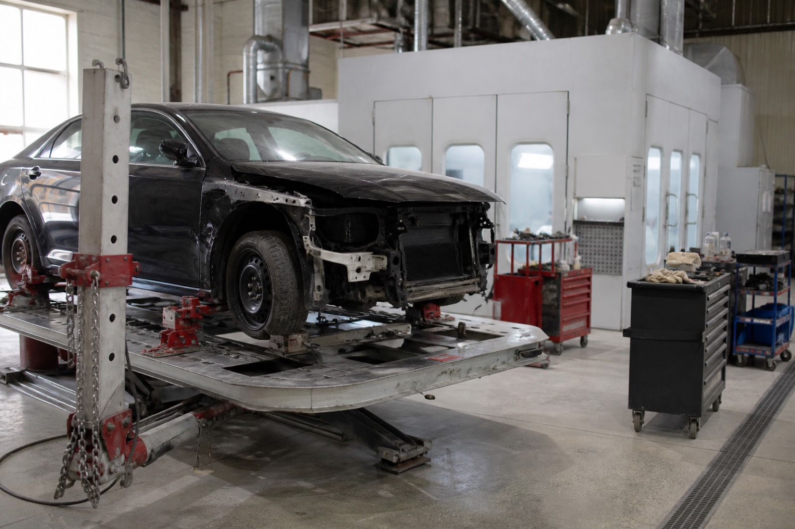 Collision repair shop floor with frame rack, central to body shop valuation