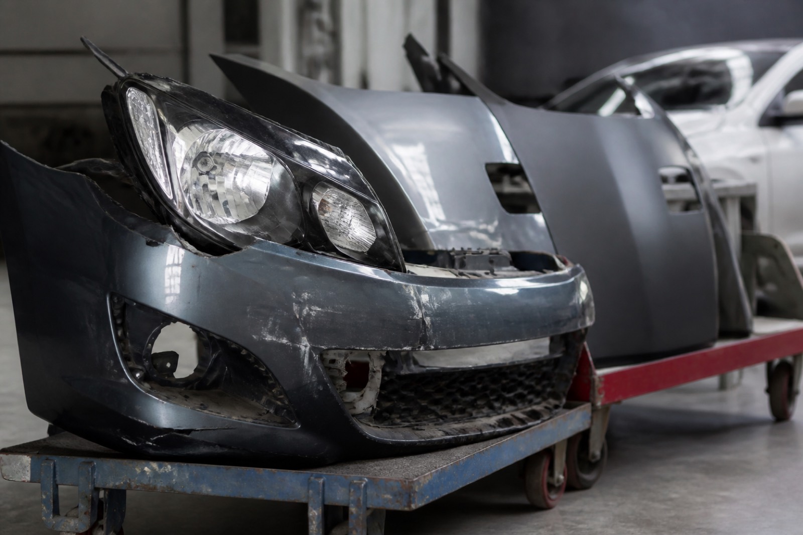 Damaged bumper and replacement parts, reflecting repair severity trends in body shop valuation