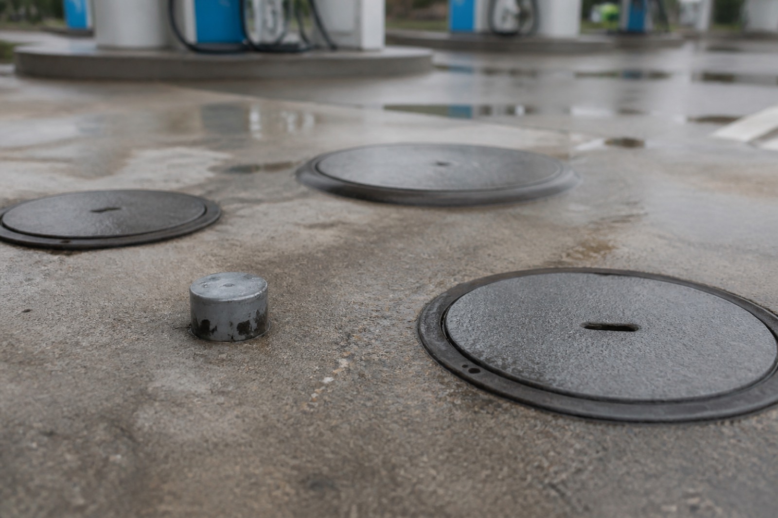 Underground storage tank access covers at a gas station forecourt