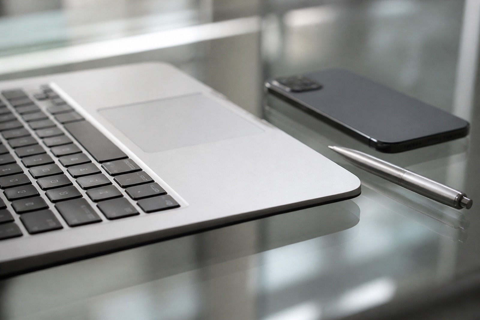 Laptop keyboard and phone on a desk used for deal software