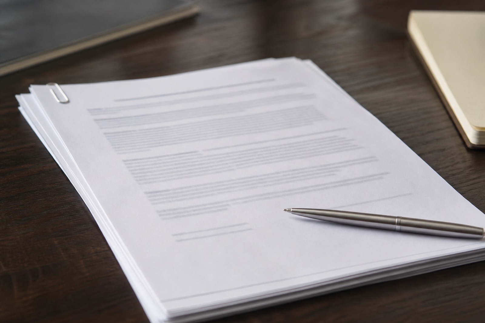Engagement letter and pen on a desk before an M&A advisor is hired