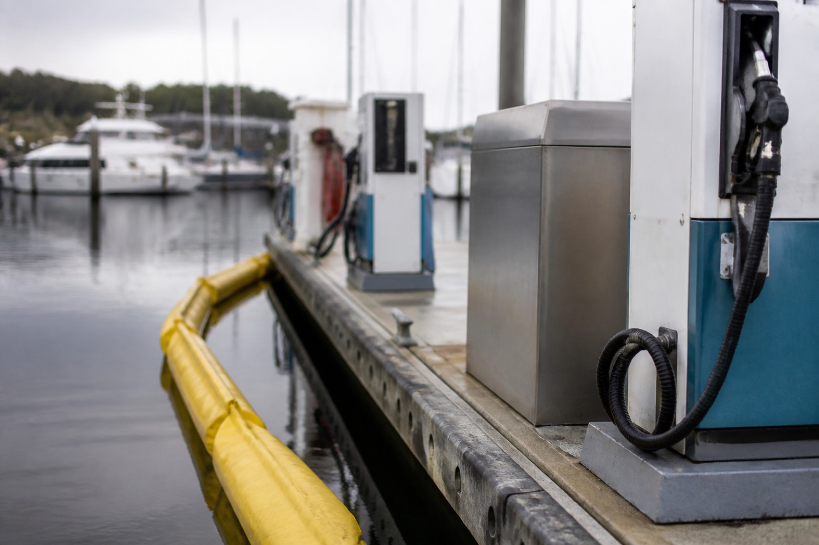 Marina fuel dock with pumps and a floating containment boom