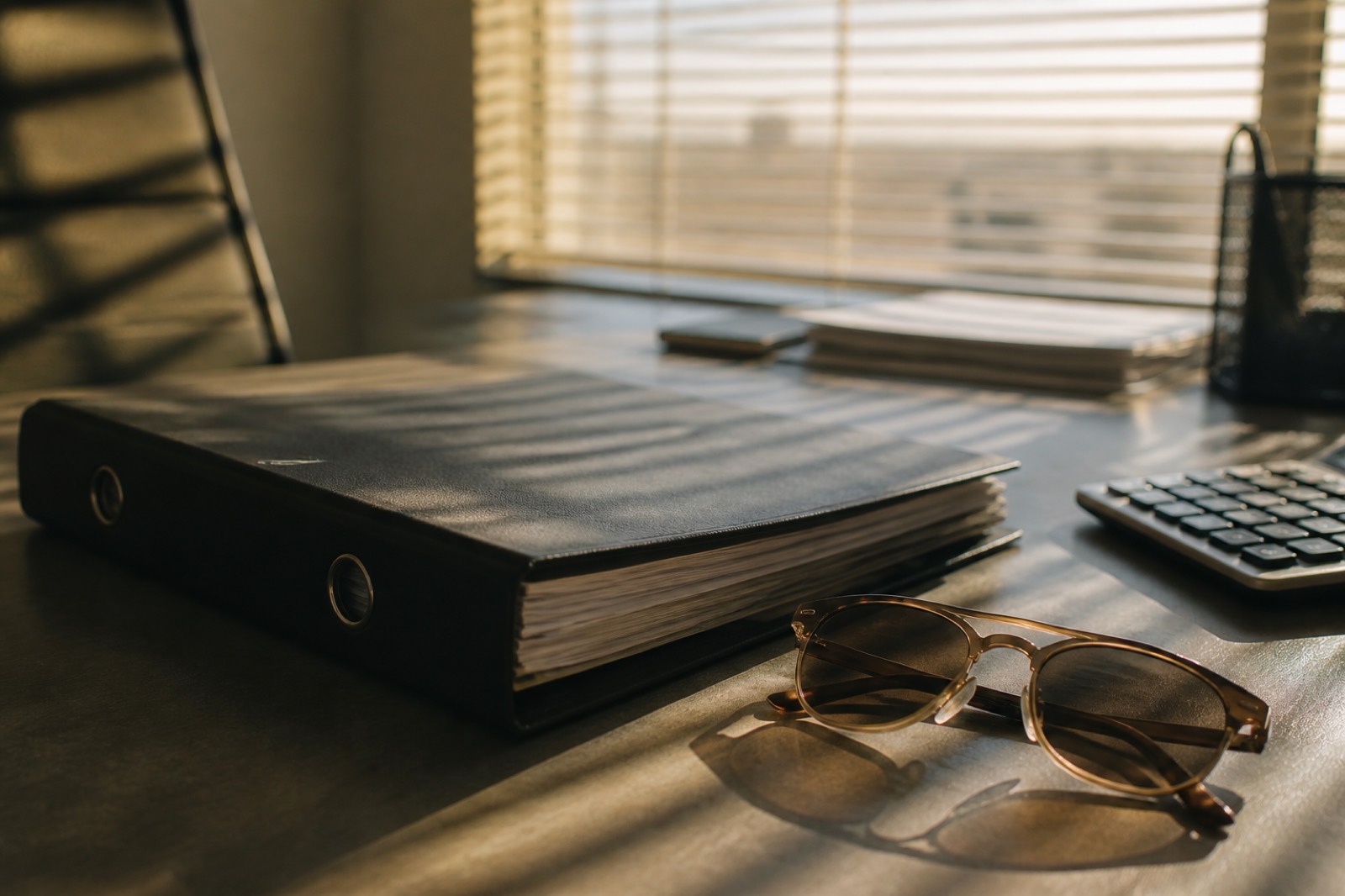 Closing binder on a desk during the sale of a pest control business in Arizona